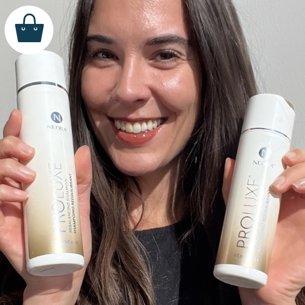 Woman smiling and holding ProLuxe Rebalancing Shampoo and Conditioner 